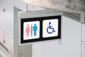 Baño accesible en centro comercial con barras de apoyo de acero inoxidable
